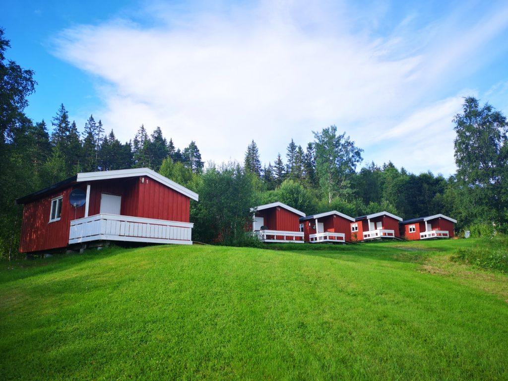 Cabins in the summer with green grass and cloudy, blue sky